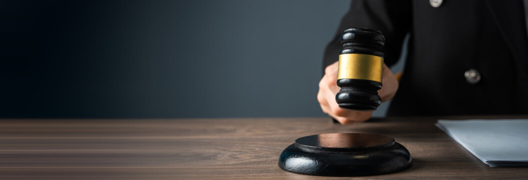 Judge holding a gavel, symbolizing authority, legal decision-making, and the administration of justice, representing fairness and the power of the courtroom.