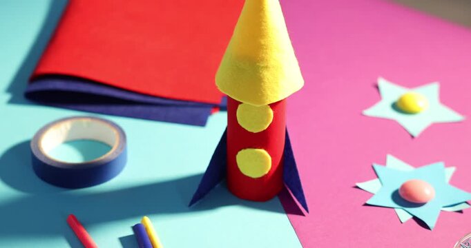 Handmade rocket and art materials on color background, closeup