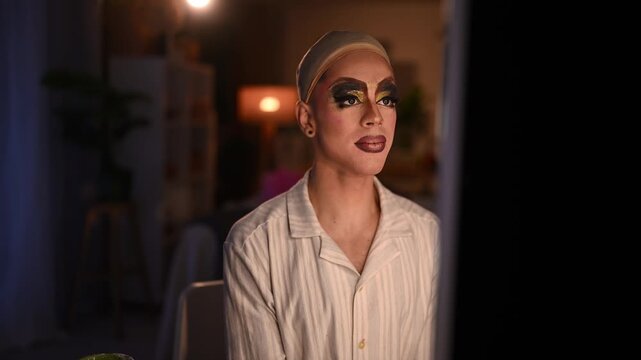 Confident drag queen sitting in a dressing room looking at the mirror with pride and satisfaction before the show