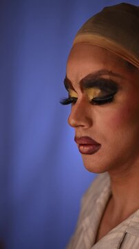 Drag queen applying eyeliner and false lashes. Male artist's backstage makeup transformation for a theatrical performance