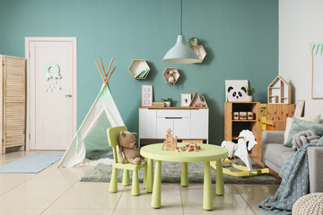 Interior of children's room with table, toys and sofa © Pixel-Shot