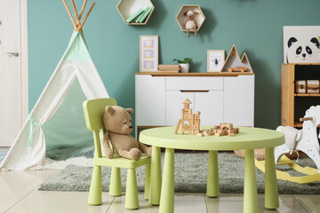 Interior of children's room with table, toys and tent © Pixel-Shot