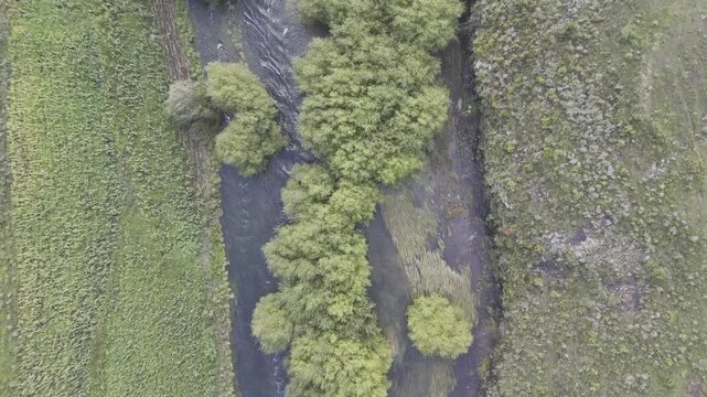 Drone with camera straight down, flies west along the Senqunyane River toward the Mohale Damon a late afternoon in the mountains of Lesotho