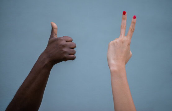 Manos de diferentes tonos de piel haciendo gestos de aprobaci&oacute;n y paz sobre fondo neutro, concepto de diversidad e inclusi&oacute;n