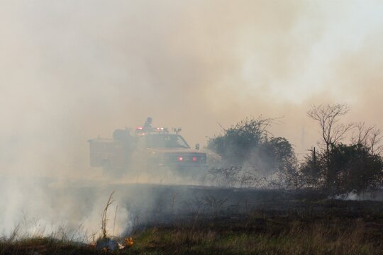 Rural firefighters are battling a grass/brush fire in heavy smoke