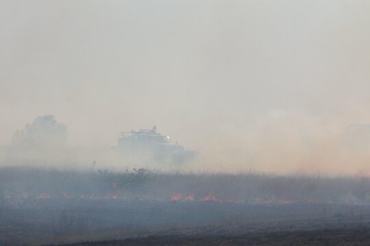 Rural firefighters are battling a grass/brush fire in heavy smoke