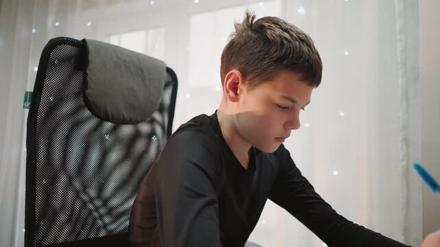 Youth studies diligently. Teenager carefully reviews notes. Focused adolescent boy practicing handwriting attentively. Young male student diligently revises with neat handwriting in calm environment