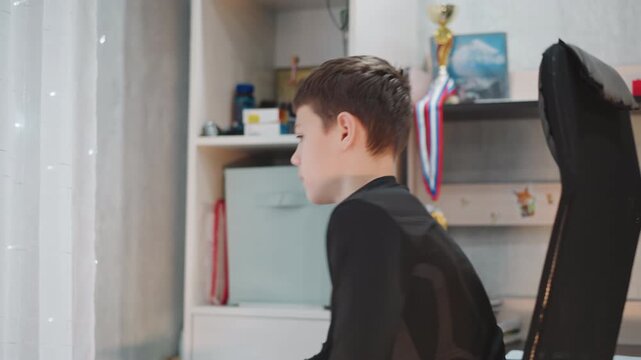 Child examines trophies and books. Curious child searches behind curtain for treasures. Inquisitive young boy scans shelves cluttered with childhood memories and favorite ornaments from his room