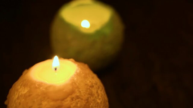 木のテーブルの上で炎が揺れる丸いキャンドル。