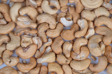 Fototapeta premium Roasted cashews macro with warm tones, artisan batch cooling on tray, visible golden browning and crunchy surface, inviting snack atmosphere for gourmet branding