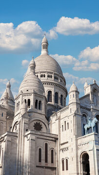 Sacr&eacute;-C&oelig;ur Basilica in Montmartre bathed in spring sunlight with fluffy clouds