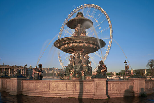 Fontaine des Mers with Grande Roue de Paris on clear spring morning in Paris