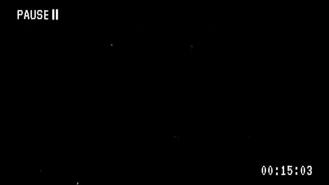 Pausing VHS video tape screen overlay with timestamp on black background 