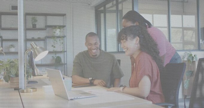 Three colleagues leaning over laptop in business, coworker pointing, operator typing, reviewing