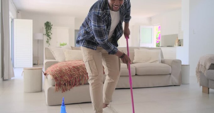 Pink mop sliding, African man grabbing and mopping floor with blue spray bottle, cleaning room