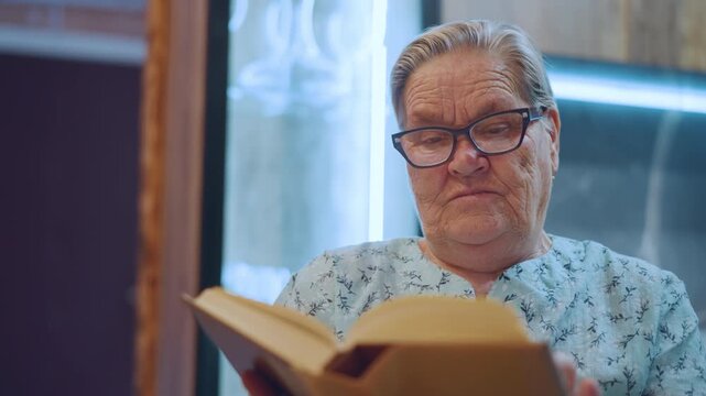 Elderly white man reading book quietly wearing patterned shirt and glasses, seated in cozy interior with soft neon backlight, flipping pages with thoughtful expression, closeup framing emphasizes