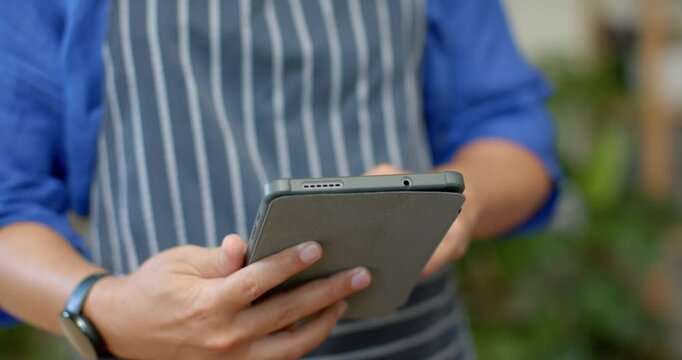 African American nonbinary holding tablet, finger starting tapping, swiping at cafe checking orders