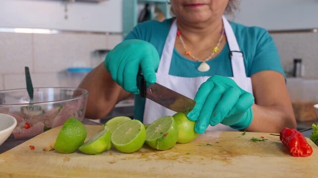 Peruvian senior chef cutting limes for ceviche preparation