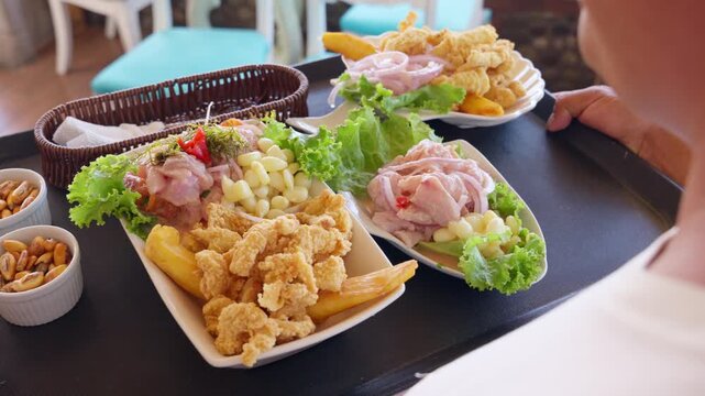 Waiter serving traditional peruvian ceviche and seafood dishes
