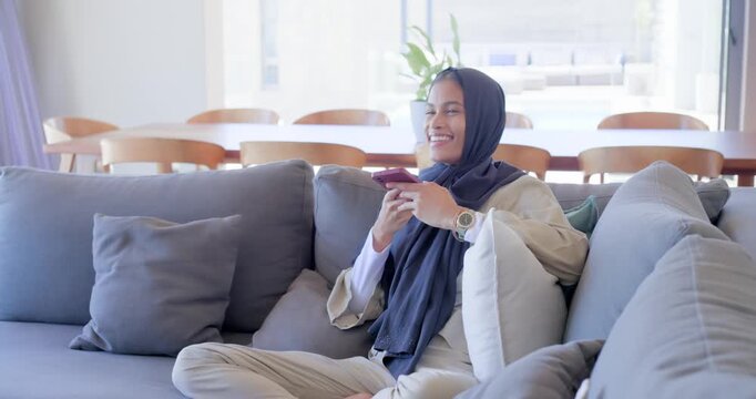 Woman holding pink smartphone starting voice message then smiling, laughing, scrolling for replies