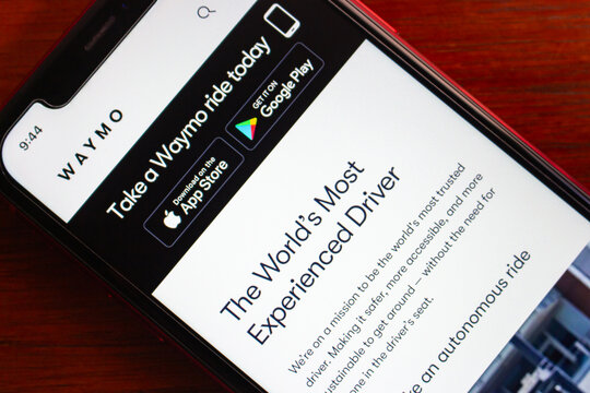 Quito, ECUADOR - Mar 2 2026 : Close-up of an iPhone on a wooden surface displaying the Waymo website.