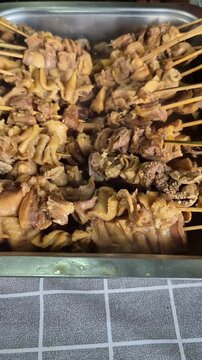 Delicious Indonesian chicken intestine satay (Sate Usus) served on a metal tray