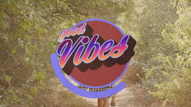 Walking two women down warm path lined with shrubs, showing growing good Vibes graphic, plaid shirt