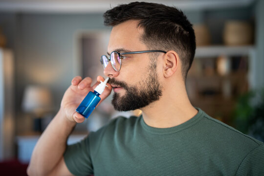 Man applying nasal spray for nasal congestion relief