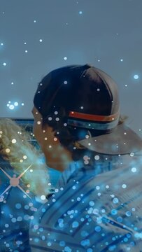 Vertical video: Man in cap turning head, wind moving hair, sparkles drifting across frame marketing