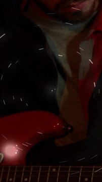 Vertical video: Guitarist tuning red guitar for music, shot rising showing strings, lights orbiting