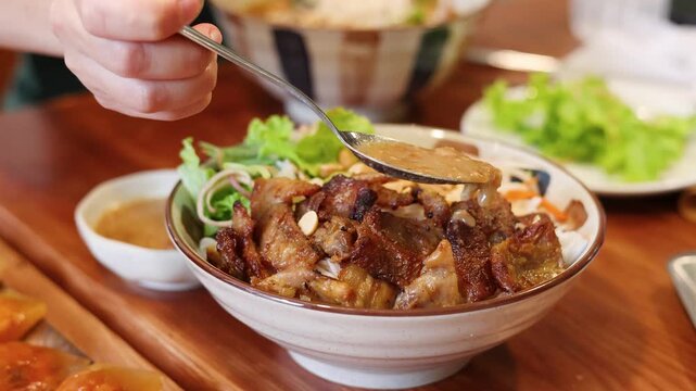 Pouring Fish Sauce Over Vietnamese Bun Thit Nuong Grilled Pork Noodle Bowl