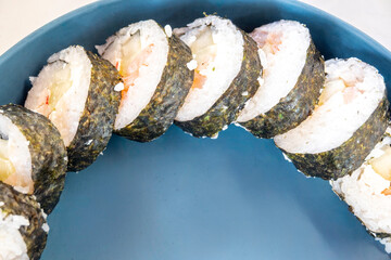 Sushi maki rolls on a blue plate, healthy japanese meal © Agustin