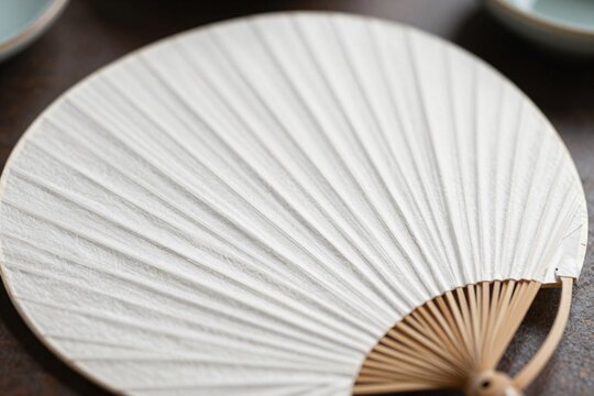 Plain white Japanese uchiwa round fan, close-up macro shot