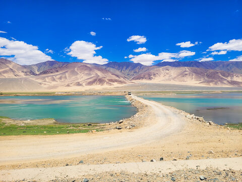 Rugged Dirt Road Causeway Crossing Turquoise Inlets of Pangong Tso Lake near Man Village in the High-Altitude Himalayas, Ladakh