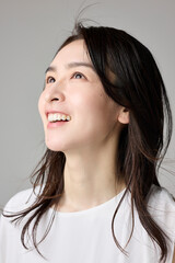 Fototapeta premium 上を見上げて笑う40代女性のポートレート