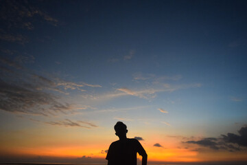 Fototapeta premium Silhouette of a man at the beach with sunset as a background