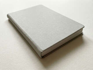 Fototapeta premium Plain Light Gray Hardcover Notebook on White Surface journal writing