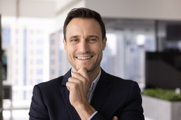Modern corporate ceo. Headshot happy successful late 30s man energetic business leader entrepreneur executive look at camera with confident smile touch chin. Profile branding portrait for social media
