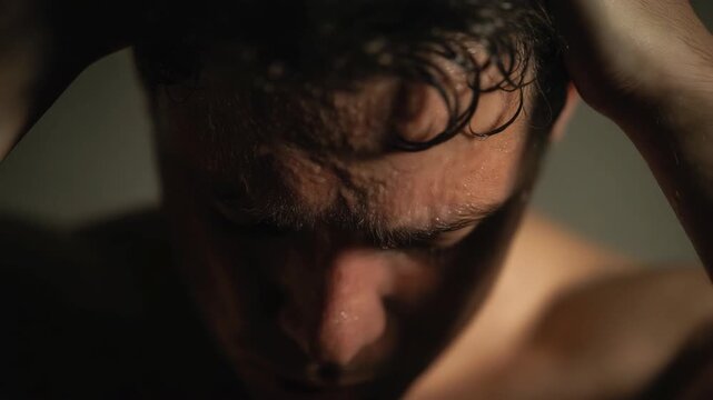 Close-up of a sporty man&rsquo;s face covered in sweat, intense expression after workout. Fitness, endurance and determination concept with dramatic lighting and high detail.