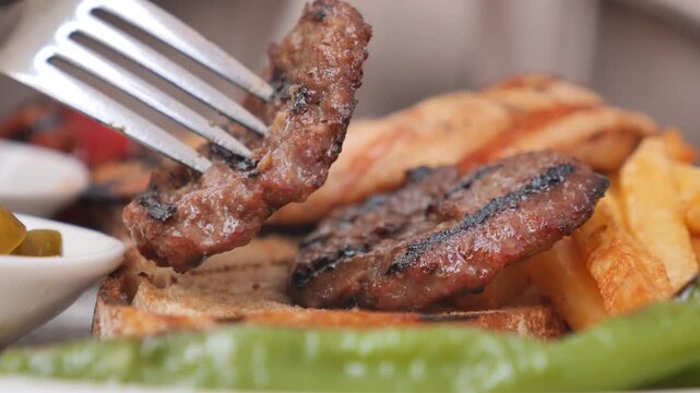 Grilled meat and fries served on a platter in restaurant