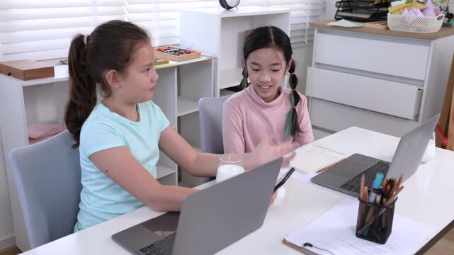 Education learning children home technology concept shows two girls studying independently with laptops at home, balancing self learning focus and digital practice in modern private education setting