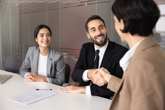 Diverse businesspeople, client and company manager handshake after signing contract, finalizing successful commercial deal in office conference room during business meeting. HR, agreement, partnership