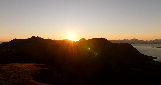 Sunrise over Storheia mountain near Stokmarknes in Hadsel Municipality Norway with ocean horizon, aerial silhouette backdrop