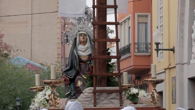 Easter procession in Alicante with religious statue and crowd watching