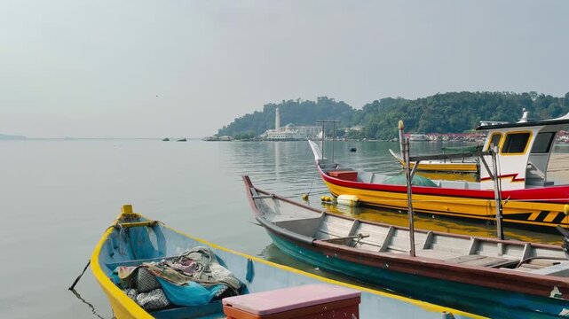 Traditional fishing willage with the boats and the floating mosque on the background in Pangkor island, Malaysia