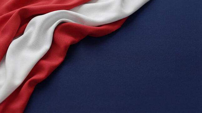 Elegant drape of red and white fabric on a deep blue background, creating a visually dynamic abstract composition.
