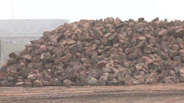​Heap of nice cobblestones, unloaded at a construction site. Gravel, granite stones, bout on the open construction site. Preparation for the construction of a new highway