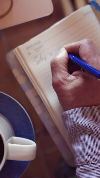 Businessman writing daily plan in notebook