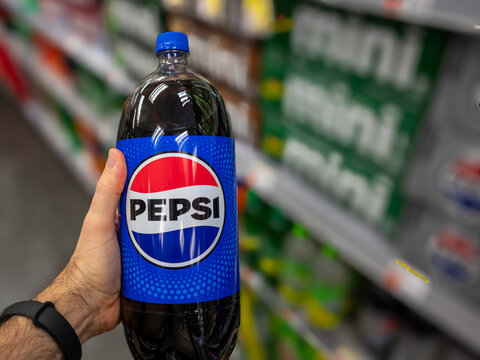New york, usa august 14,2024. Customer reaches for a large pepsi cola bottle on a supermarket shelf, selecting a carbonated soft drink in the aisle