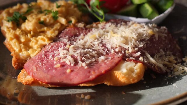 Close up food plate with scrambled eggs salami and cheese motion food photography.